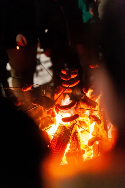 Assar salsichas sobre fogo no inverno — Fotografia de Stock