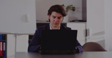 Ev ofisinden laptopla çalışan genç bir iş adamı.. 
