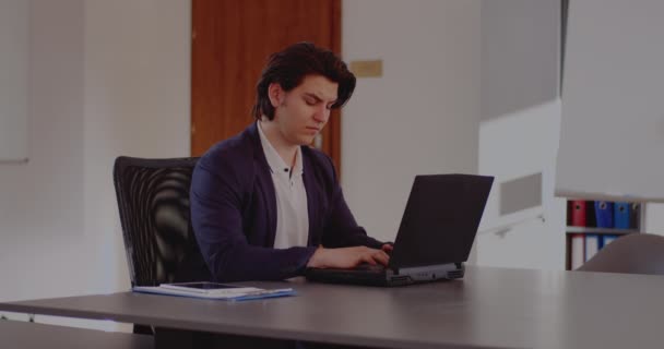 若いビジネスマンは自宅のオフィスからラップトップで働いています. — ストック動画