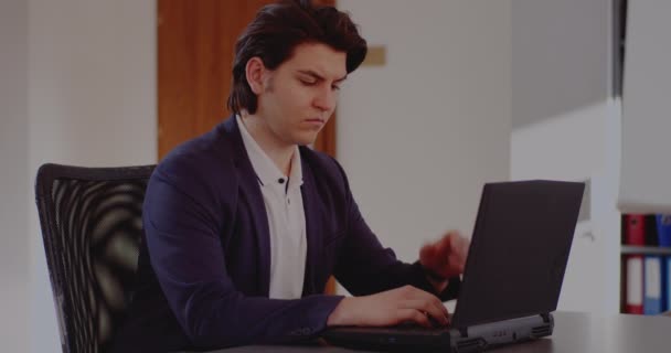 Frustrado joven empresario que trabaja en el ordenador portátil — Vídeo de stock