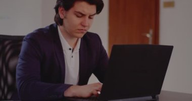 Ofiste dizüstü bilgisayar kullanan gergin genç işadamı
