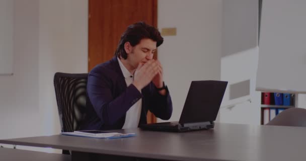 Уставший бизнесмен с ноутбуком в офисе — стоковое видео