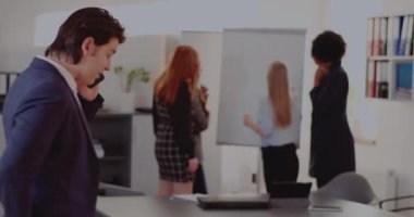 İşadamı ofiste akıllı telefondan konuşuyor.