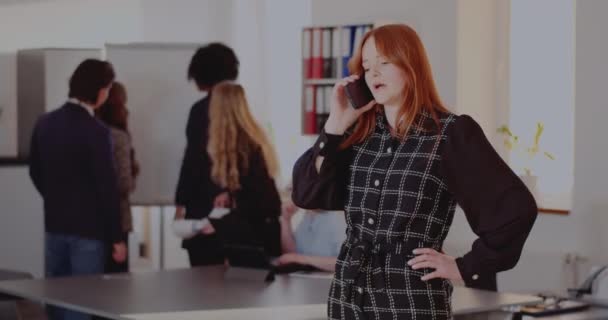 Affärskvinna pratar på smarttelefon på kontoret — Stockvideo