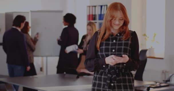 Üzletasszony üzenetküldés okostelefonon az irodában — Stock videók