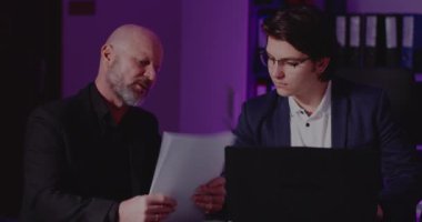 Erkek ve bayan meslektaşlar ofiste geç saatlere kadar çalışıyor.