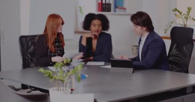 İş adamı iş arkadaşlarıyla belge üzerinde tartışıyor