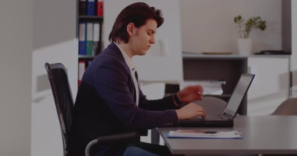 Empresario ensangrentado usando portátil en la oficina — Vídeos de Stock