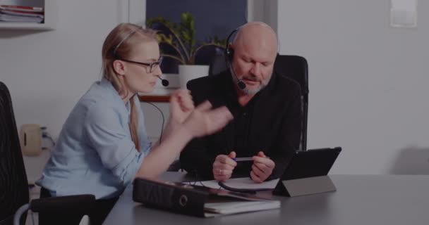 Colegas con auriculares discutiendo en la reunión en línea — Vídeo de stock