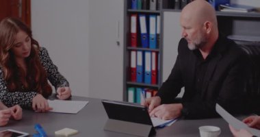 Yönetici meslektaşlarıyla yaptığı toplantıda raporları imzalıyor