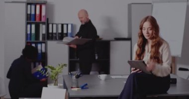 Ofisteki masada tablet bilgisayar kullanan bir iş kadını.