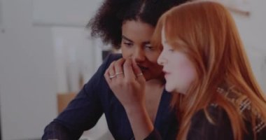 Kadın iş arkadaşları ofiste tartışıyor.