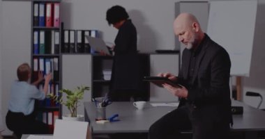 Ofiste tablet bilgisayar kullanan bir işadamı.