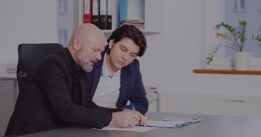 Erkek meslektaşlar ofiste stratejiyi tartışıyor