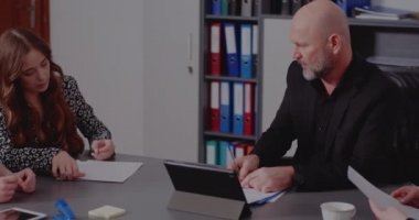 Yönetici meslektaşlarıyla yaptığı toplantıda raporları imzalıyor