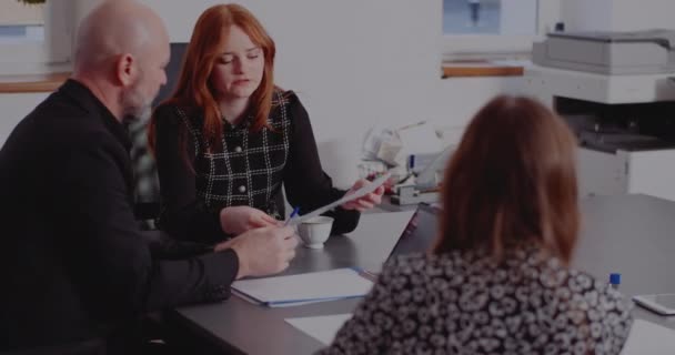 Chers collègues discutant de documents dans la salle de conseil — Video