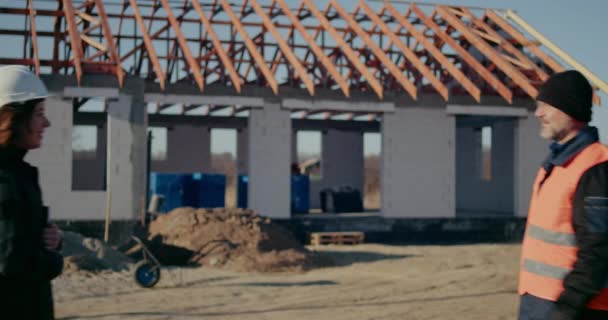Ingeniero y trabajador estrechan la mano en el sitio de construcción. Concepto del sitio de construcción. — Vídeos de Stock