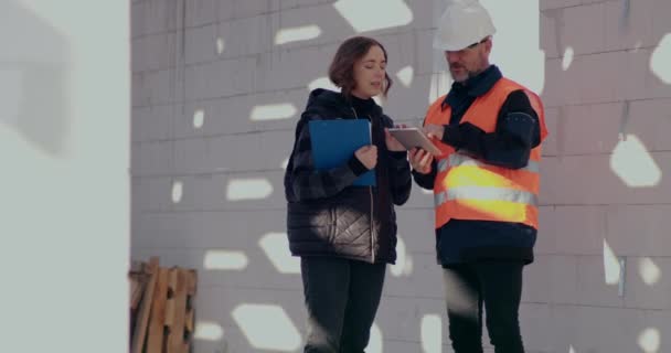 Geconcentreerde ingenieurs bespreken, onderzoeken en ontwikkelen op bouwplaats — Stockvideo