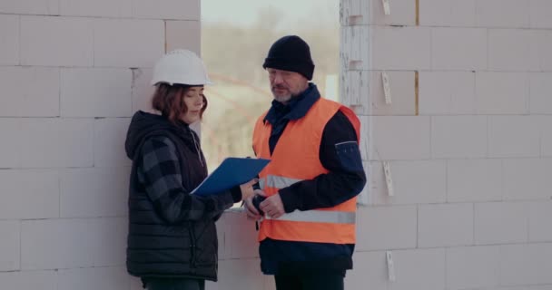 Konzentrierte Ingenieure diskutieren, untersuchen und entwickeln auf der Baustelle — Stockvideo