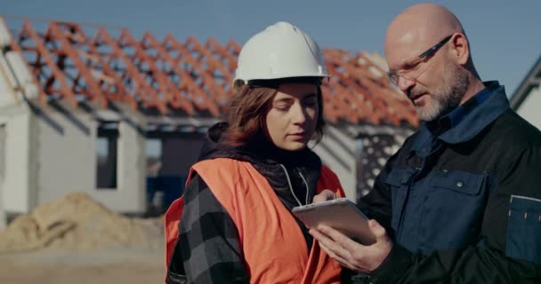 Ingénieurs concentrés discutant, examinant et développant sur le chantier — Video