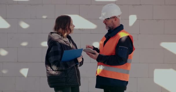 Geconcentreerde ingenieurs bespreken, onderzoeken en ontwikkelen op bouwplaats — Stockvideo