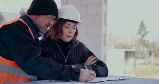 Concentrated Engineers discussing, examining and developing at Construction Site — Stock Video