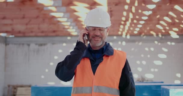 Trabalhador de Costrução falando no celular no canteiro de obras — Vídeo de Stock