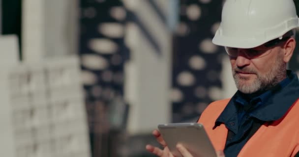 Εργάτης κατασκευής χρησιμοποιώντας ψηφιακή ταμπλέτα στο εργοτάξιο — Αρχείο Βίντεο