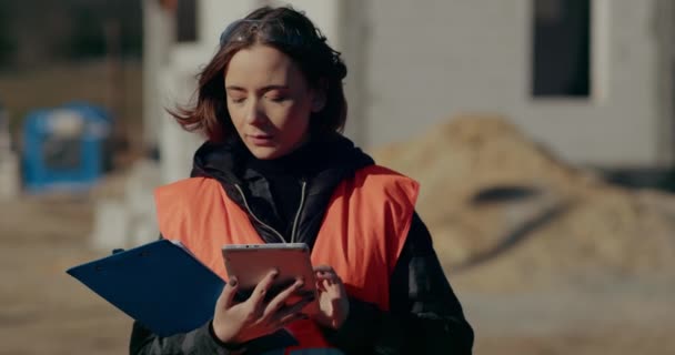 Bouwkundig ingenieur met behulp van digitale tablet op bouwplaats — Stockvideo