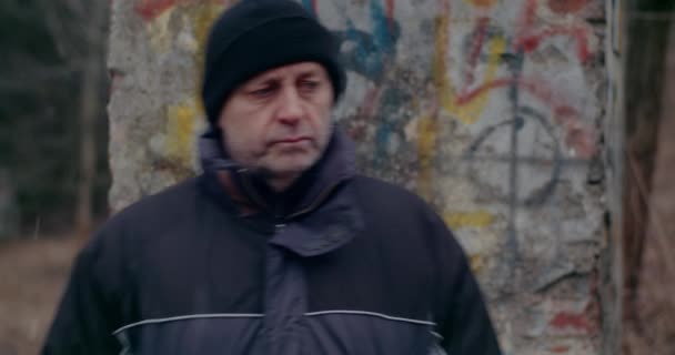 冬の戦争中に考える思慮深いホームレスの男. — ストック動画