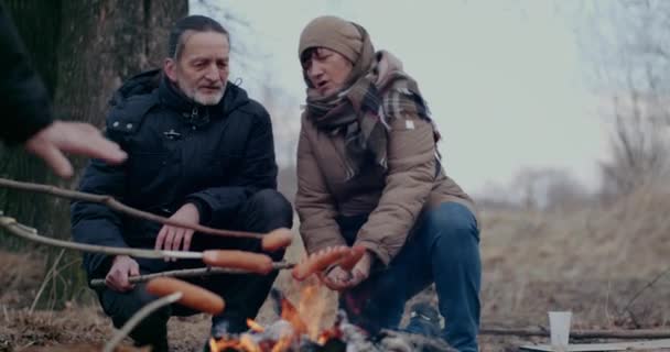 Ukrainska flyktingar Rostade korvar vid Bonfire. — Stockvideo