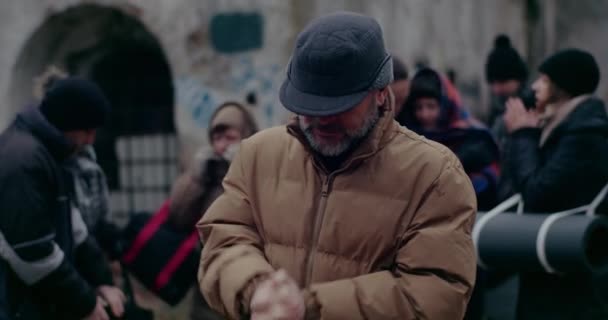 Hajléktalan férfi menekült Dörzsölje a kezét hideg időben a háború alatt. — Stock videók