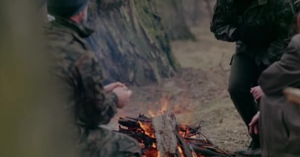 Soldaten en vluchtelingen warmen handen bij het vreugdevuur. — Stockvideo
