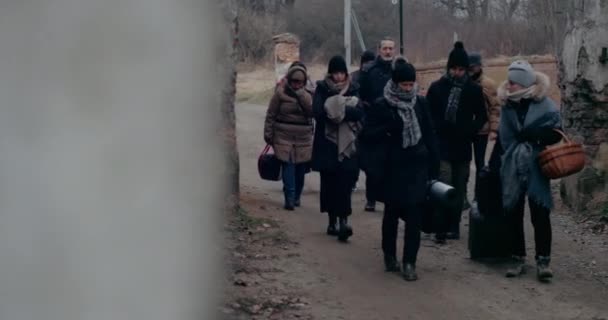 Біженці мігрують в холоді через руїни під час війни. — стокове відео