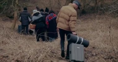 Mültecilere doğru yürürken bavulunu çeken adam..