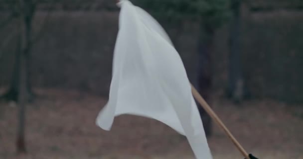 Refugiado de mano recortada ondeando bandera blanca durante la guerra. — Vídeo de stock