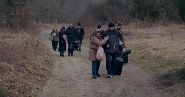Военные иммигранты ходят с багажом на дороге во время снегопада. — стоковое видео