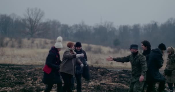 Armeesoldaten helfen Flüchtlingen beim Sprung über Schützengraben. — Stockvideo