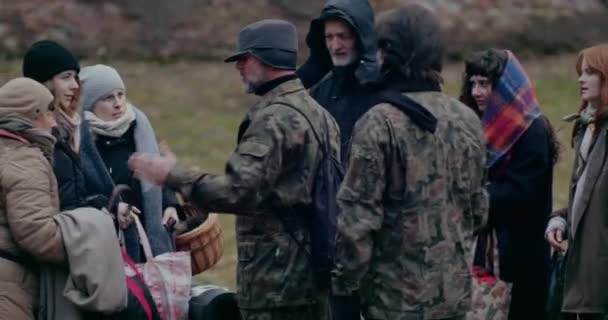 Військові обговорюють групу безпритульних біженців . — стокове відео