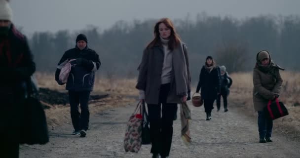 Deprimovaná žena bez domova se zavazadly procházející se mezi uprchlíky. — Stock video