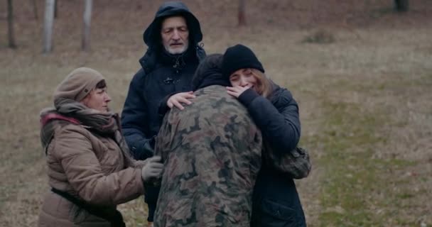 Sorglig familj omfamning och seeing off militär son under kriget. — Stockvideo