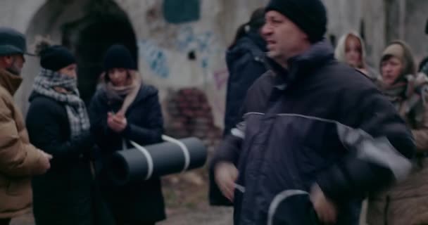 Hajléktalan férfi bevándorló dörzsöli a kezét hidegben a háború alatt. — Stock videók
