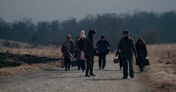 Soldiers Walking Ahead Of Refugee Group On Road. — Stock Video