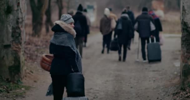 Ung kvinna med bagage ser tillbaka under kriget. — Stockvideo