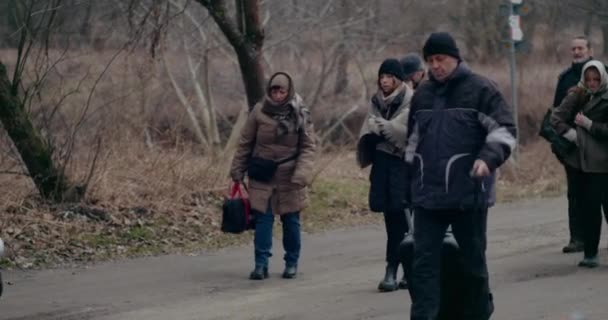 Hajléktalan menekültek gyalogolnak az úton, miközben vándorolnak a háború alatt. — Stock videók