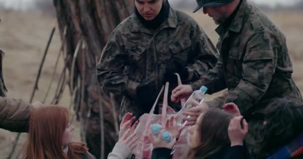Soldados distribuyendo comida y agua a los refugiados durante la guerra. — Vídeo de stock