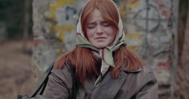 Besvärad ung rödhårig kvinna som gråter under kriget på vintern. — Stockvideo