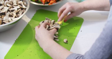 Mutfakta yemek pişirmek için mantar doğramak.