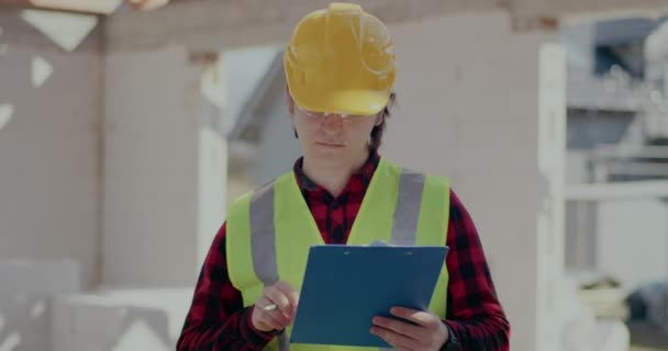 Confident young male contractor holding clipboard — Video