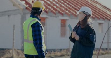 Kızgın kadın yönetici erkek inşaat işçisini azarlıyor.